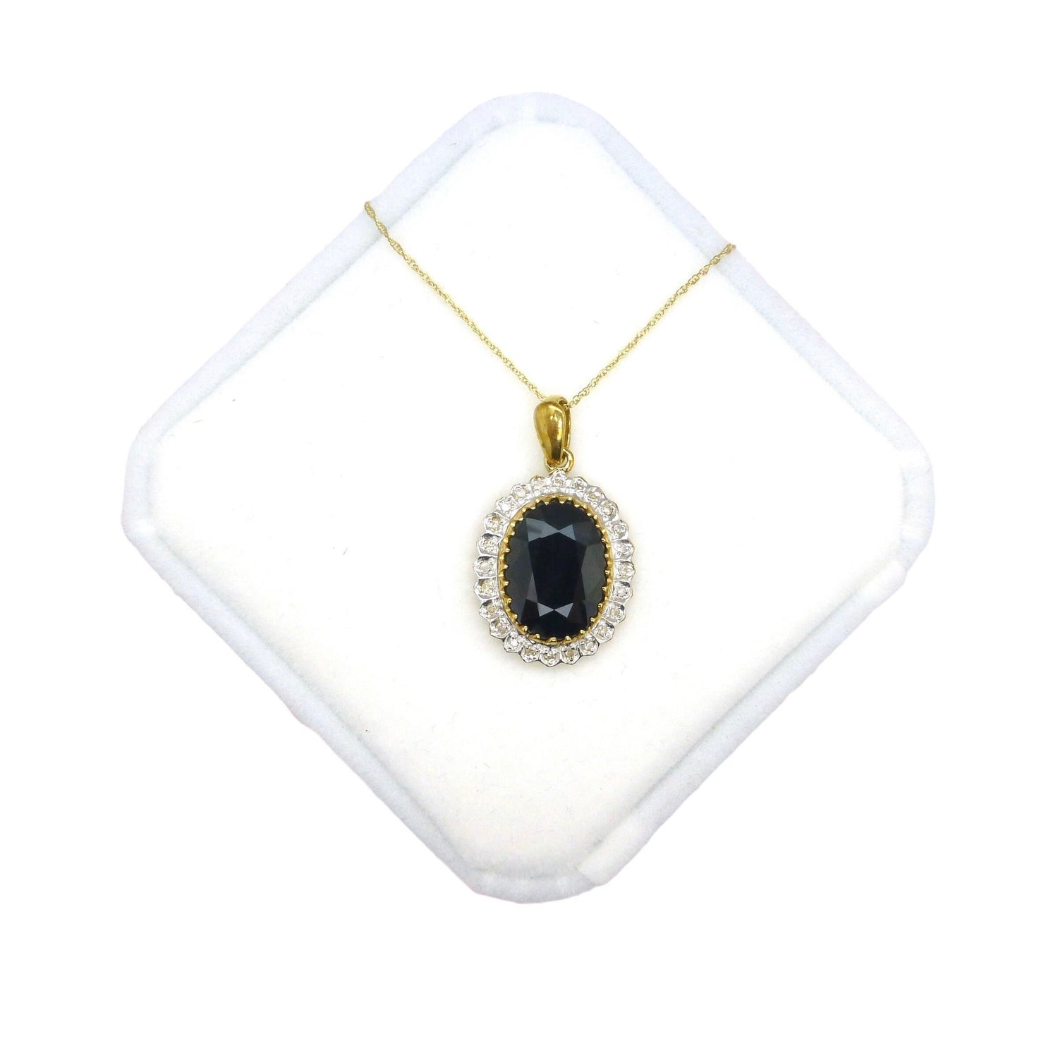 Vintage large oval black sapphire pendant surrounded by tiny diamonds suspended on a fine gold chain.