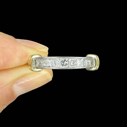 Vintage 14k white gold princess cut channel set diamond ring with goldshoulder accents set against a black background